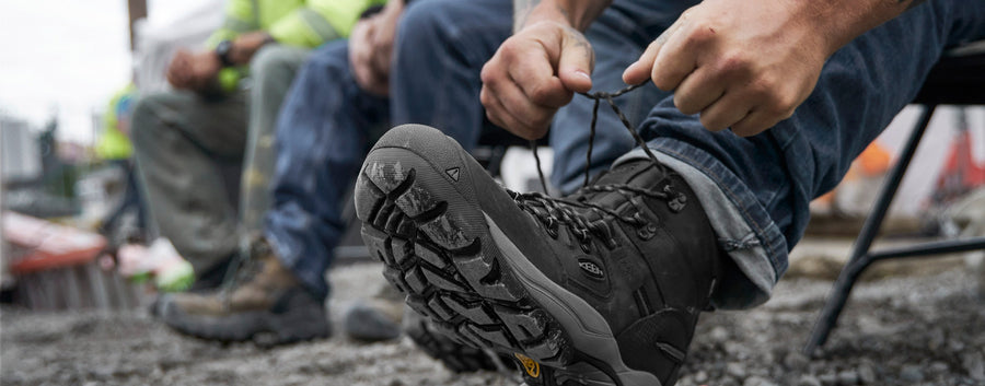 person lacing up work boots