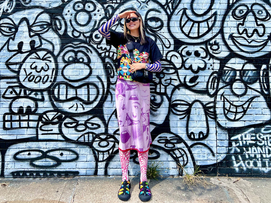 A creative person with colorful, unique style, wearing rainbow KEEN Newport sandals