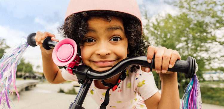 a girl smiling while riding a bike
