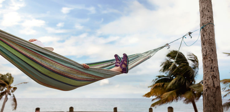 A child relaxing in a hammock at the beach