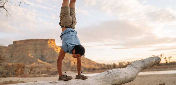 a man doing a handstand on a trail