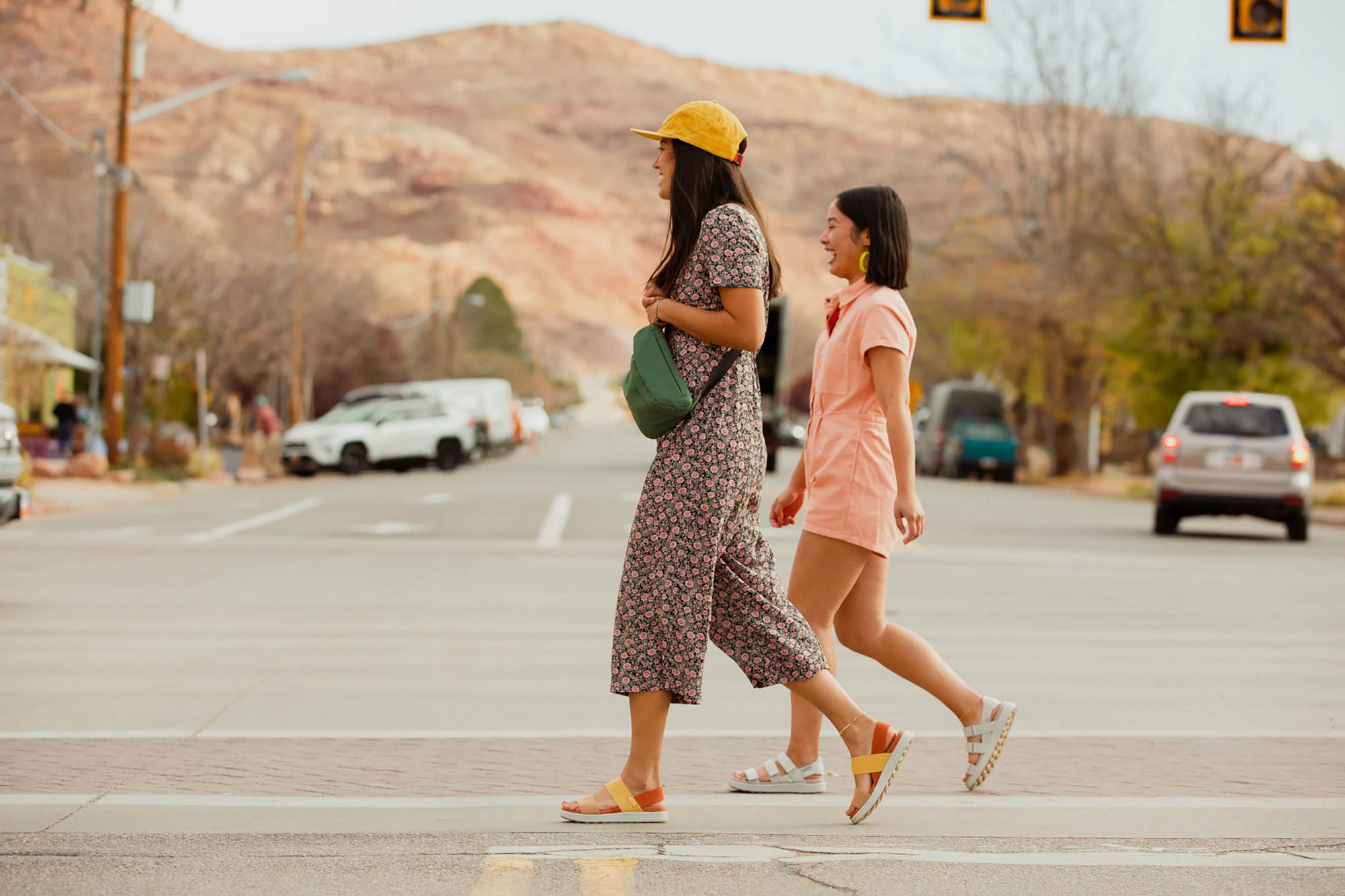 two women cross the street in stylish walking sandals
