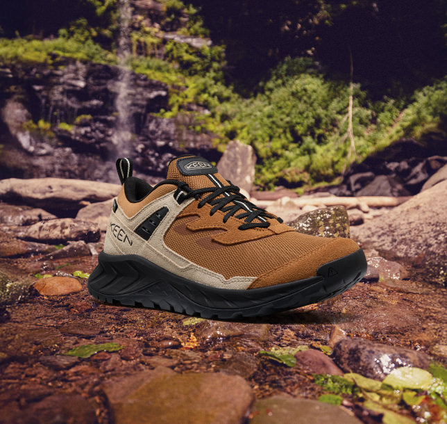 A pair of men's new Hightrail hiking shoes resting on rocky terrain, showcasing their rugged design and grip.