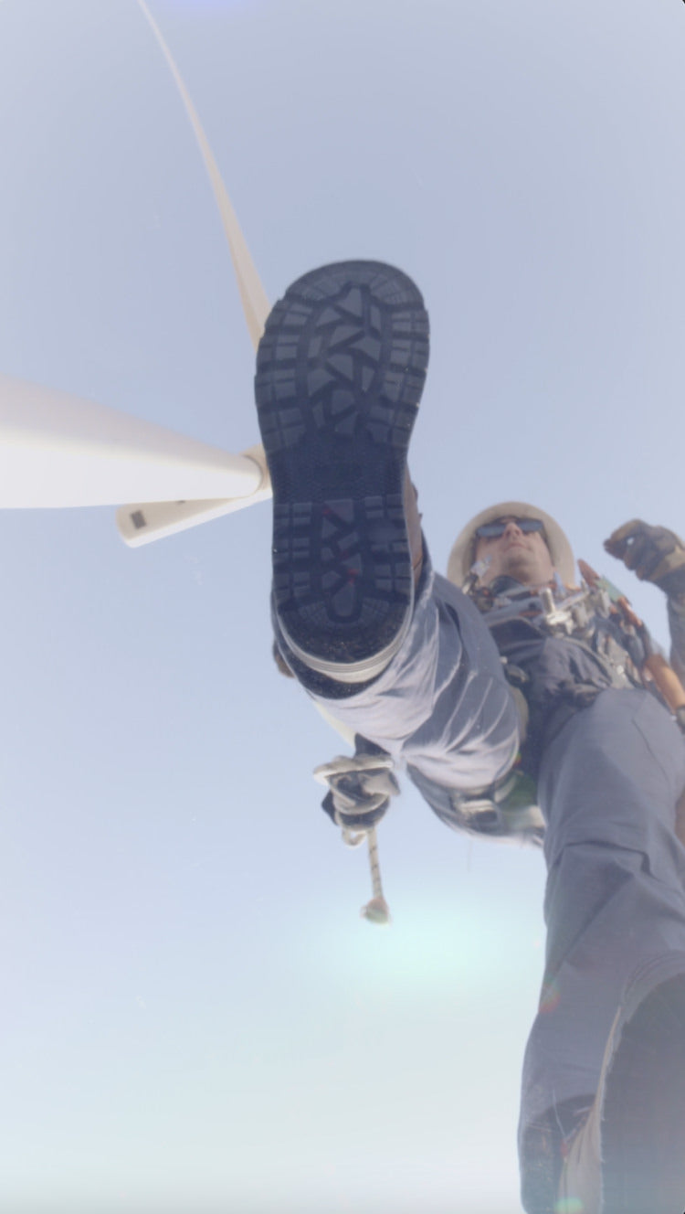 Man working under wind-turbine walking over glass surface wearing Camden boots