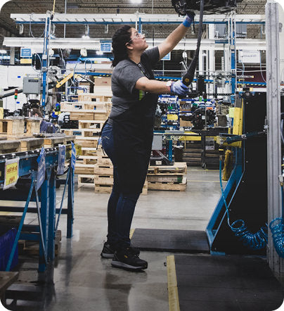 A woman working in a factory, operating machinery.